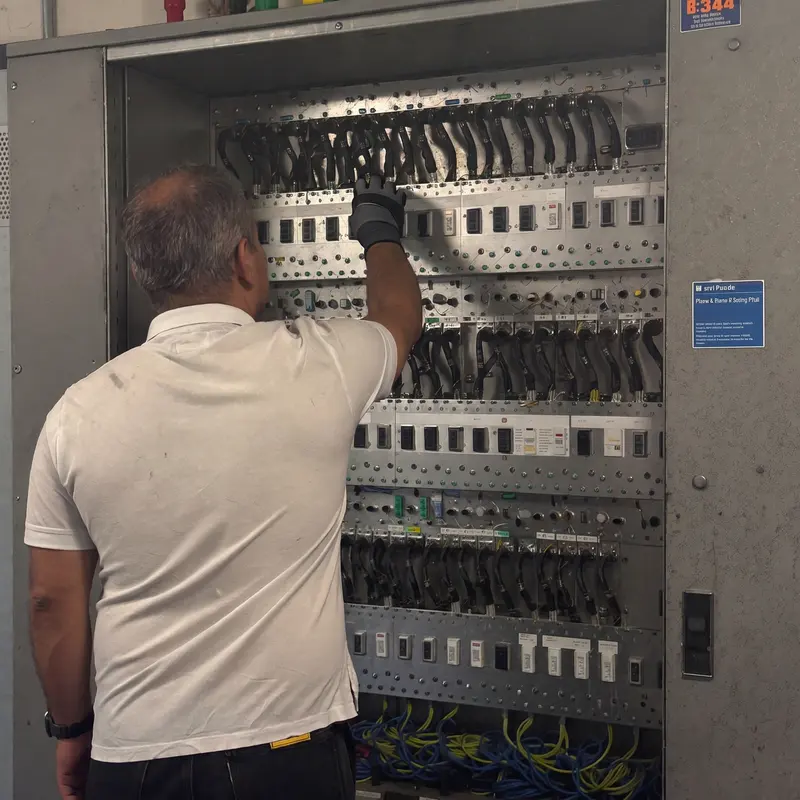 An electrician inspecting a large distribution board