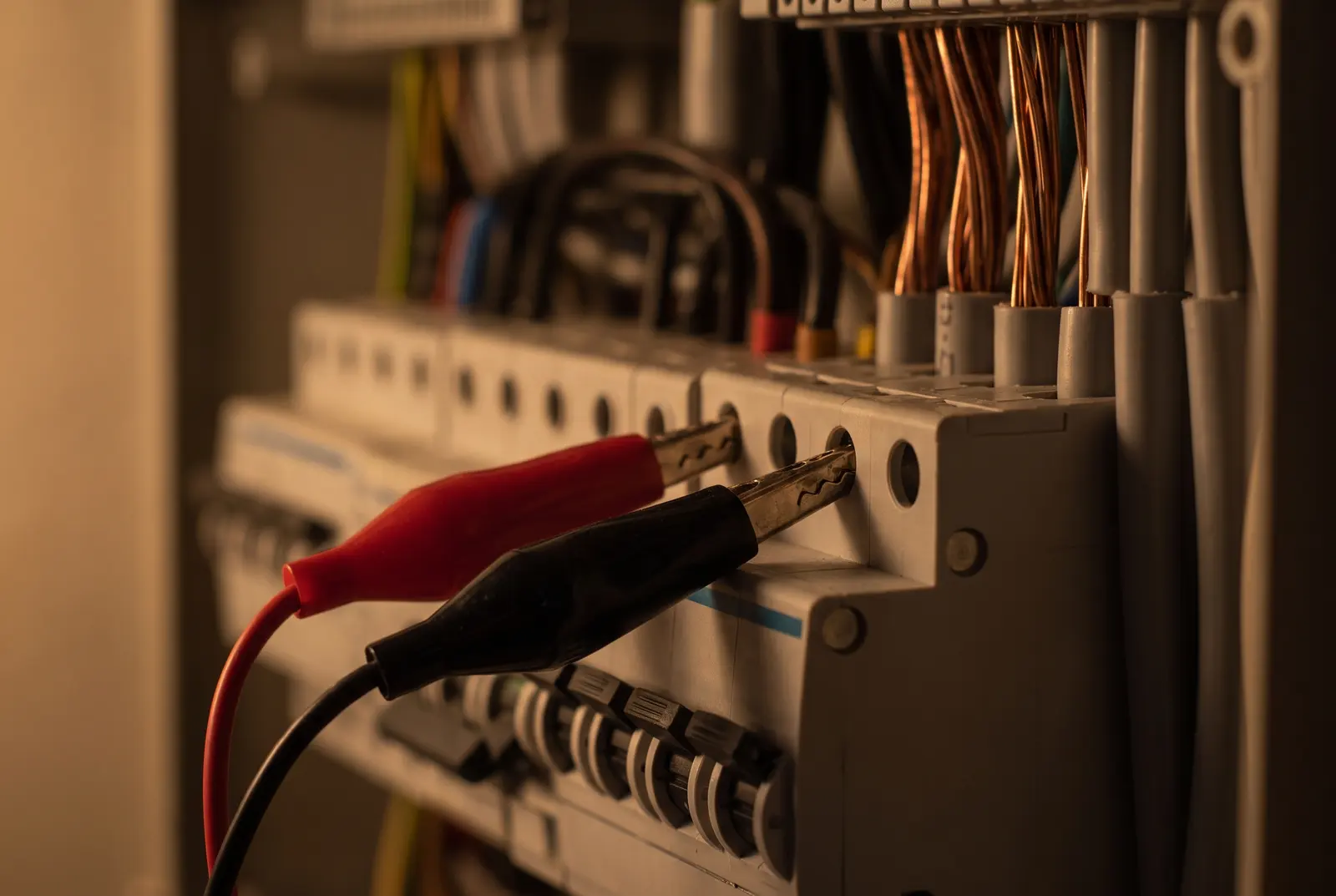 Test leads clipped to the terminals of a consumer unit