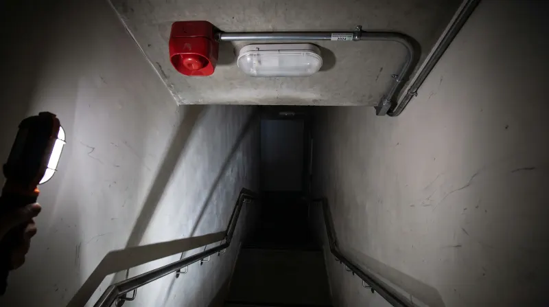 An emergency light and fire alarm sounder in a commercial stairwell, examined on an emergency call-out in Barking