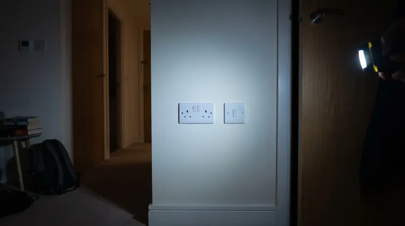A flush socket and switch plate in a modern flat, examined on an emergency call-out in Canary Wharf