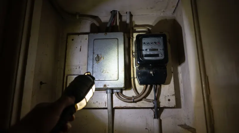 An original mid-century fuse box and meter in a hallway cupboard, found by an emergency electrician in Hainault