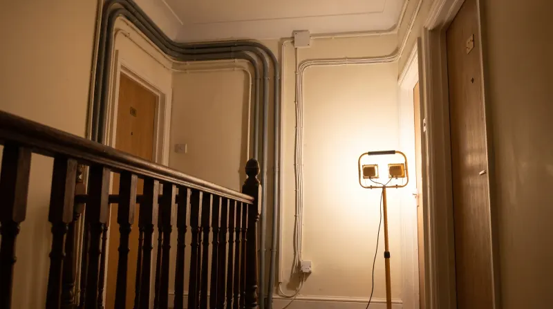 Surface-run cable to separate flat entrances on a landing, examined on an emergency call-out in Ilford