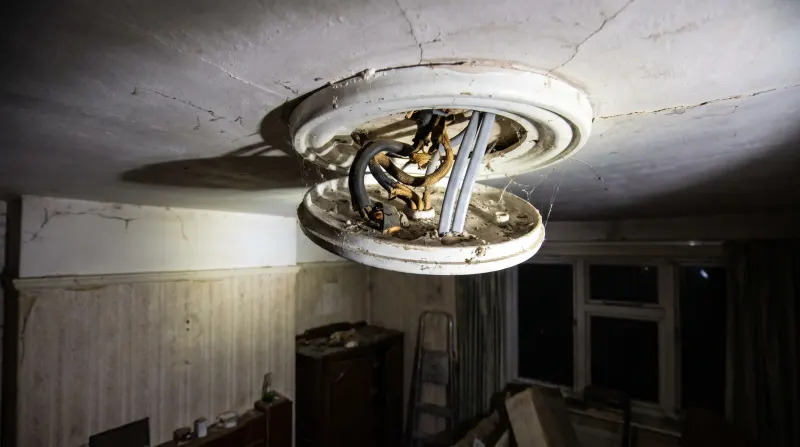 Perished rubber-sheathed cable exposed at a ceiling rose, examined on an emergency call-out in Leyton