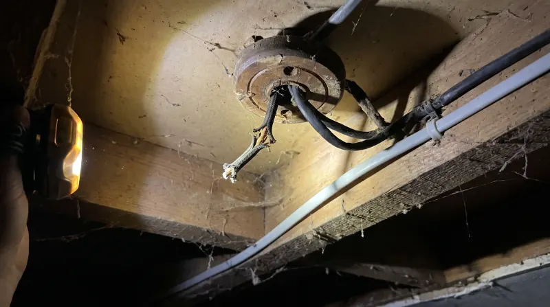 Perished rubber-sheathed cable exposed at a ceiling rose, examined on an emergency call-out in Walthamstow