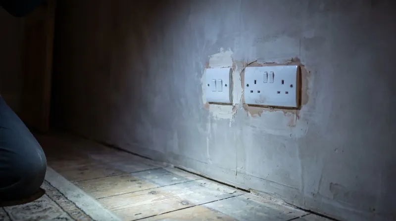 A new switch and socket on a replastered wall, examined on an emergency call-out in your area