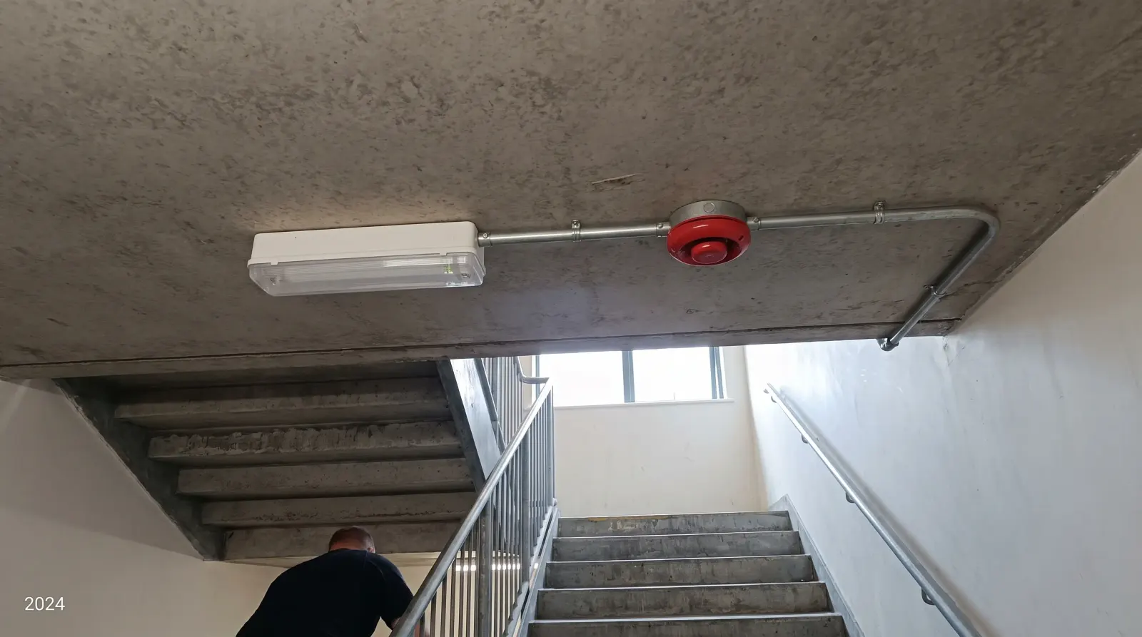 An emergency light and fire alarm sounder in a commercial stairwell — emergency lighting in Epping