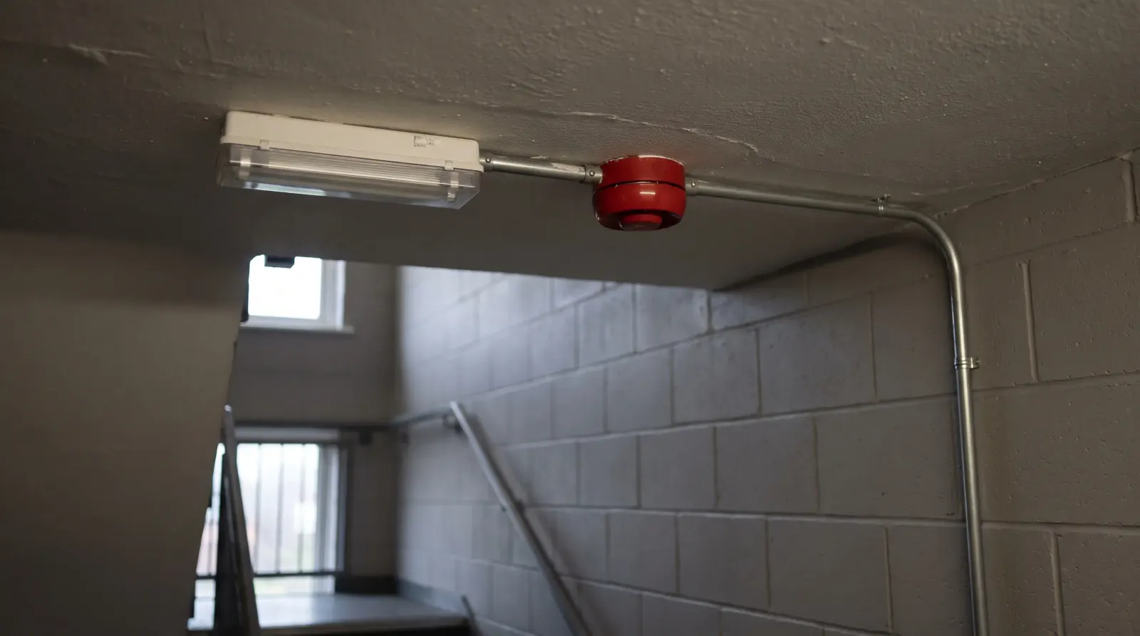 An emergency light and fire alarm sounder in a commercial stairwell — the kind of emergency lighting an electrician in Gravesend is called out for