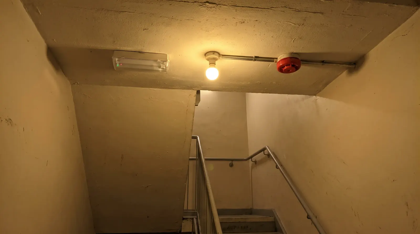 An emergency light and fire alarm sounder in a commercial stairwell — emergency lighting in Lewisham