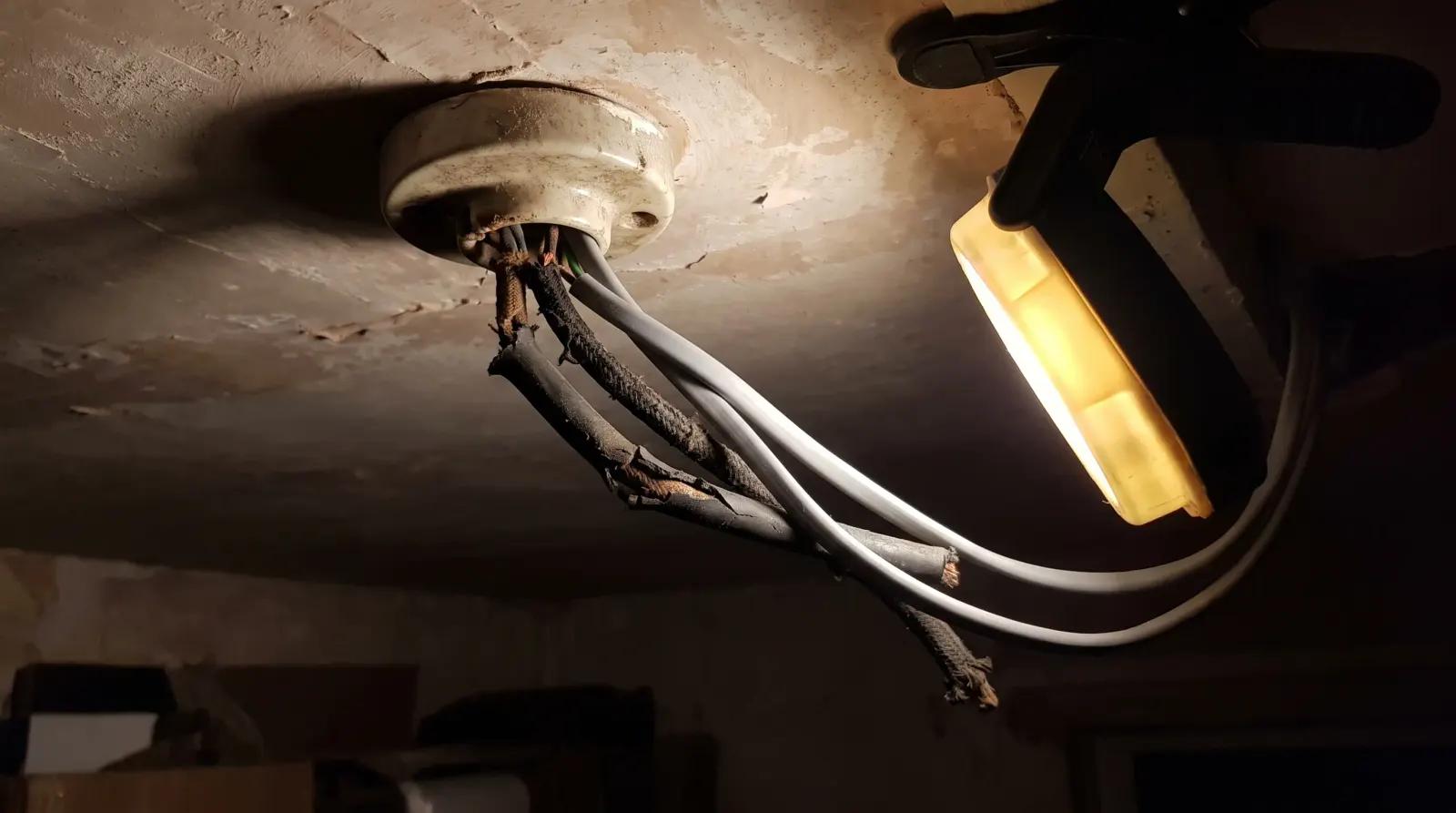 Perished rubber-sheathed cable exposed at a ceiling rose — the kind of house rewire an electrician in Erith is called out for