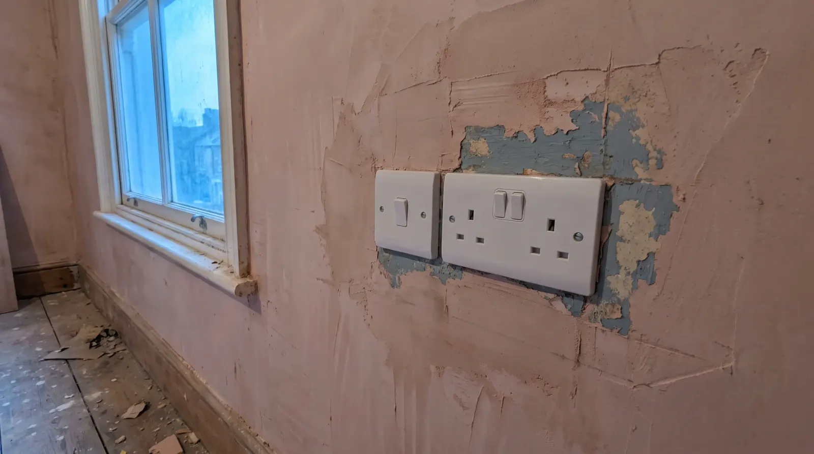A new switch and socket on a replastered wall — new sockets and lighting in Walthamstow
