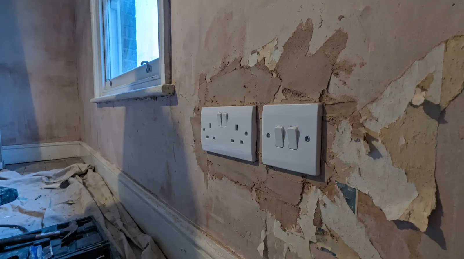 A new switch and socket on a replastered wall — new sockets and lighting in Wanstead