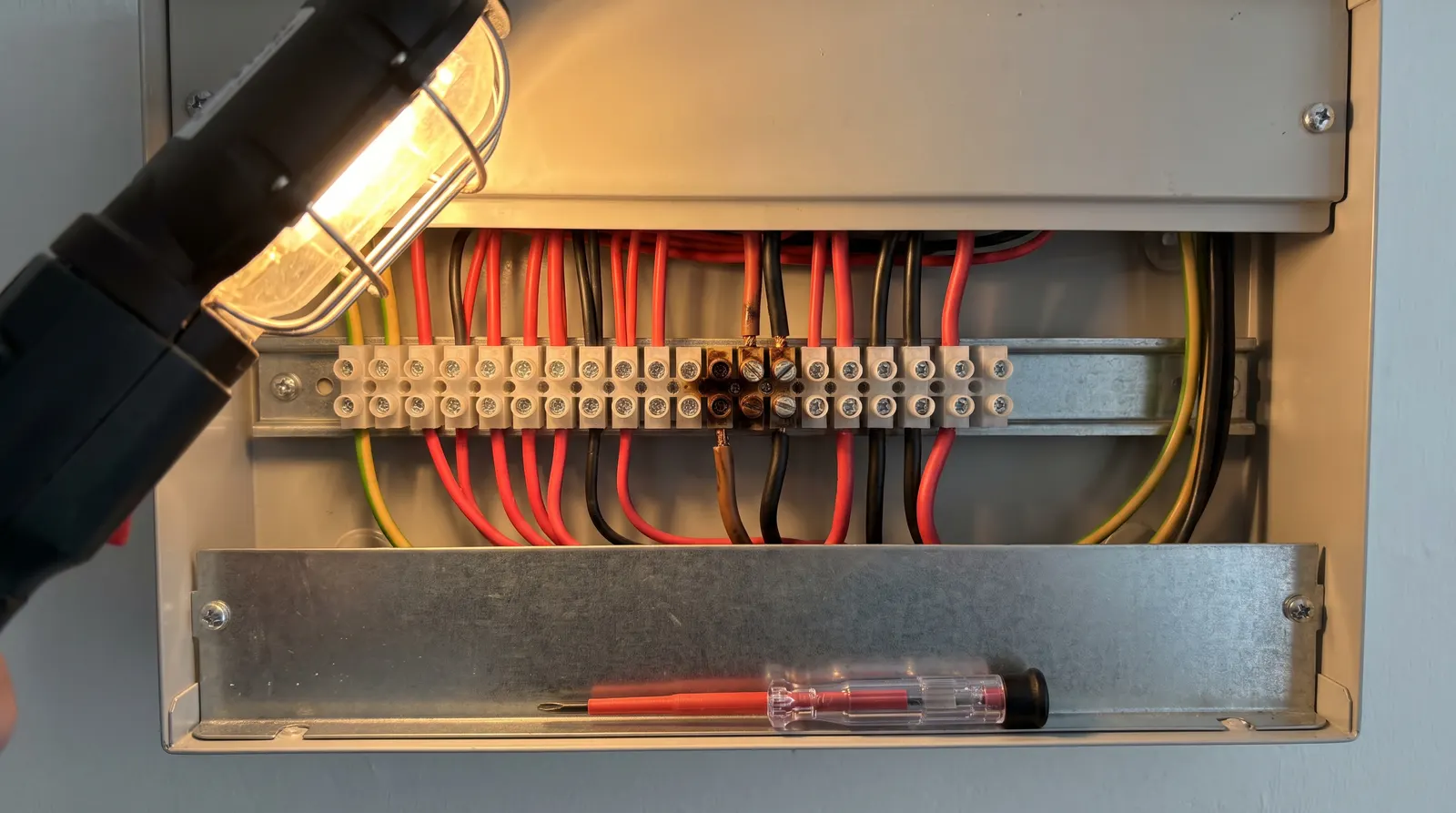 A loosened, discoloured terminal connection inside an open consumer unit