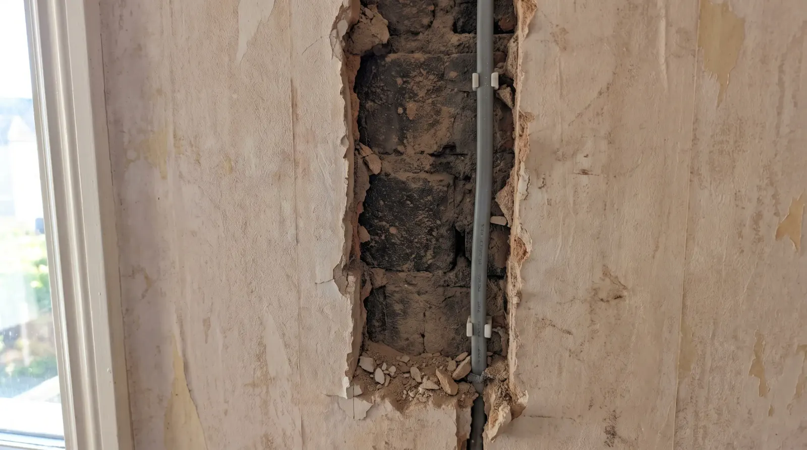 A bedroom wall chased out for new cable — house rewire in Harold Wood