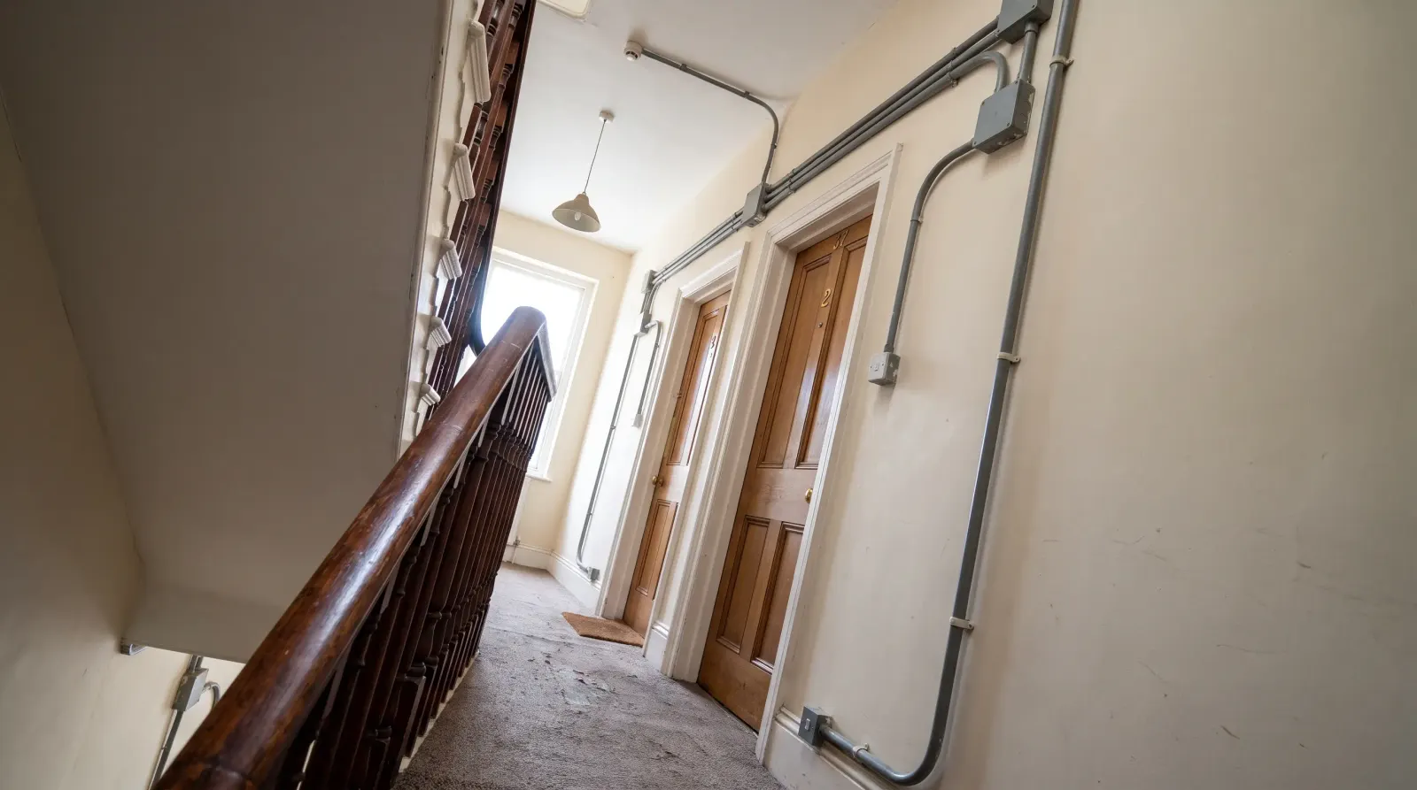 Surface-run cable to separate flat entrances on a landing — the kind of rewiring an electrician in Muswell Hill is called out for