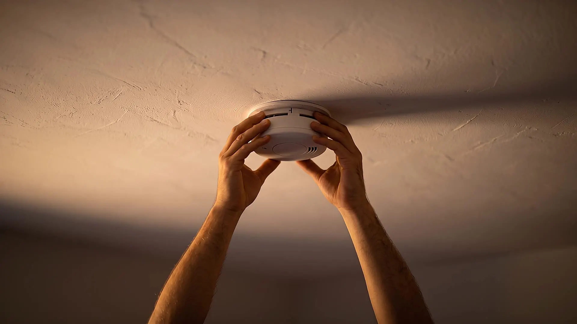 Two interlinked ceiling smoke alarms along an upstairs landing