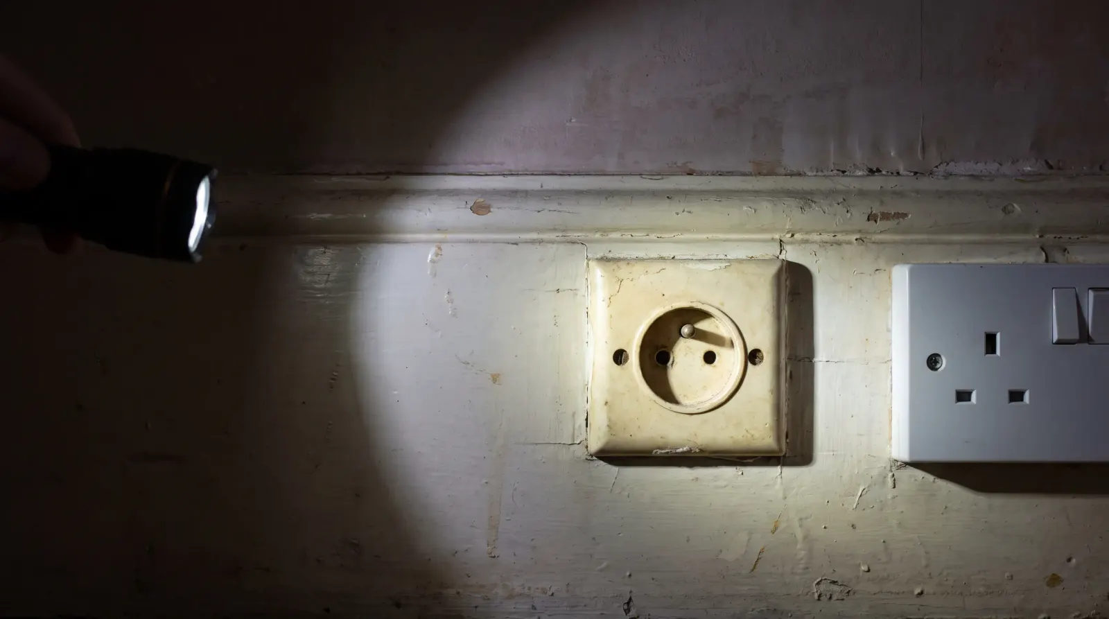 A surviving round-pin socket next to a modern three-pin one — the kind of new sockets an electrician in Harold Wood is called out for
