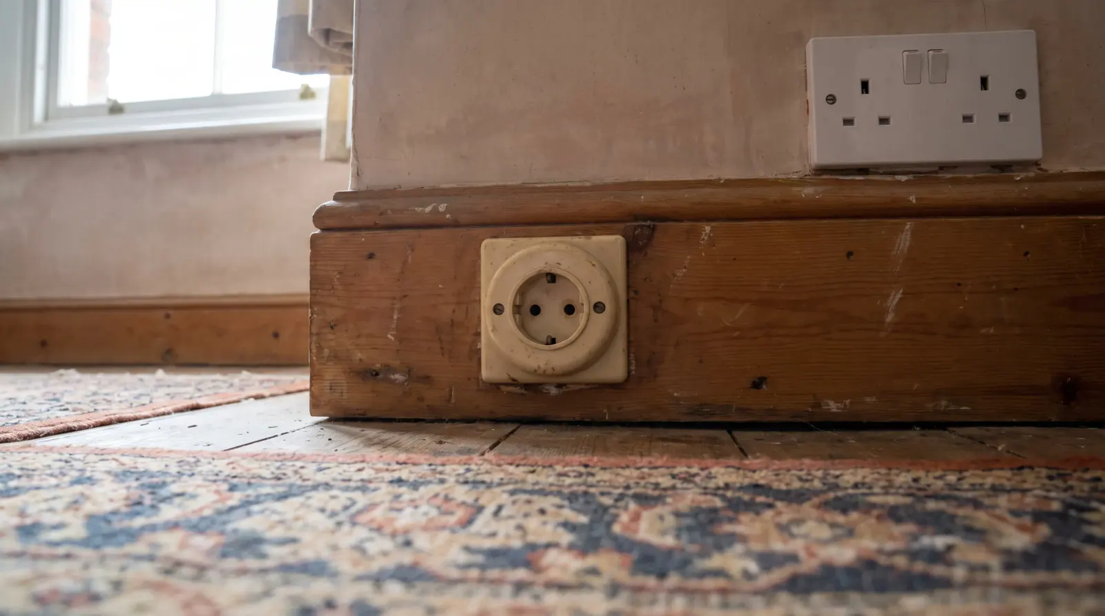 A surviving round-pin socket next to a modern three-pin one — the kind of new sockets an electrician in Welling is called out for