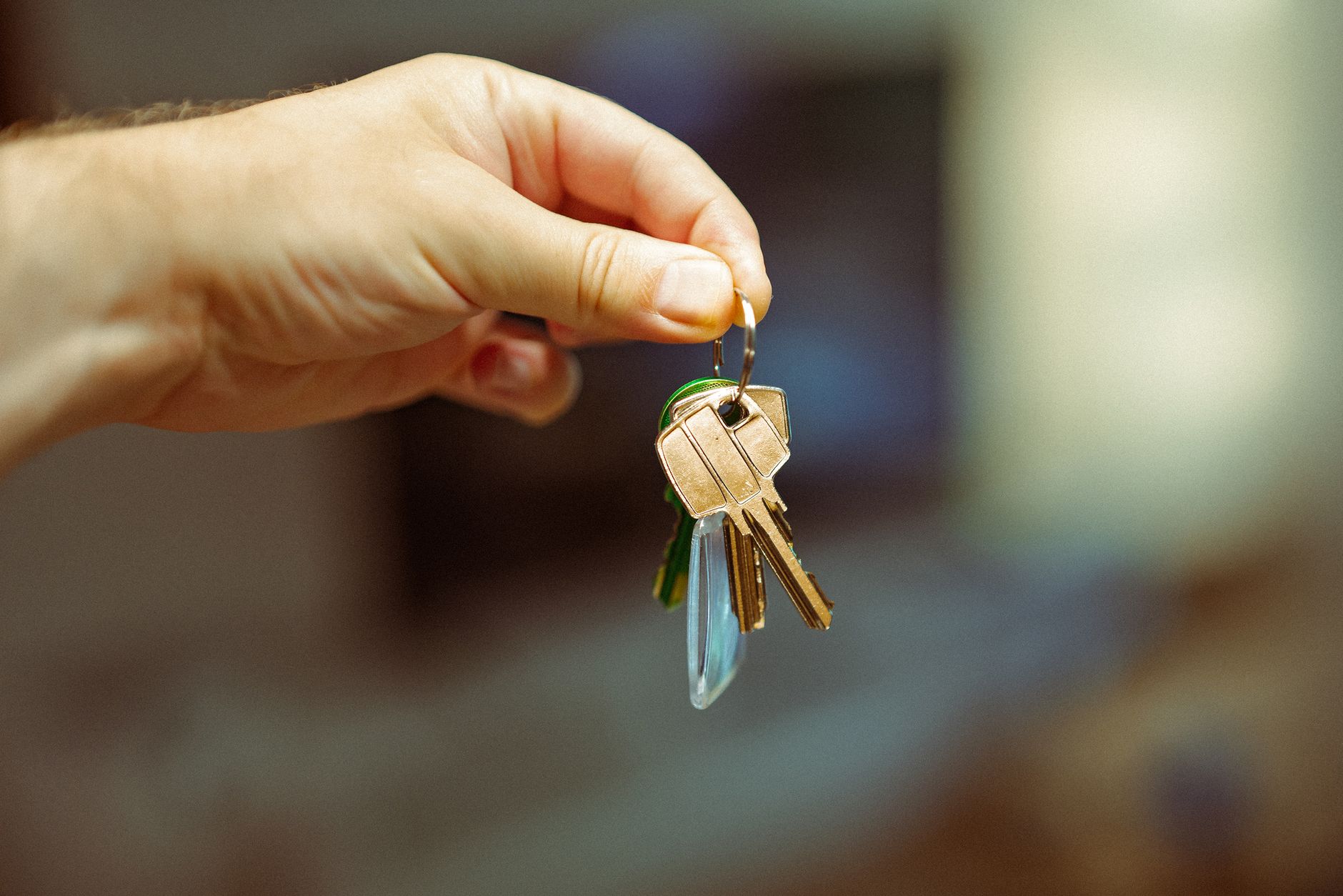 Hand holding a set of house keys, representing a new tenancy in a rental property