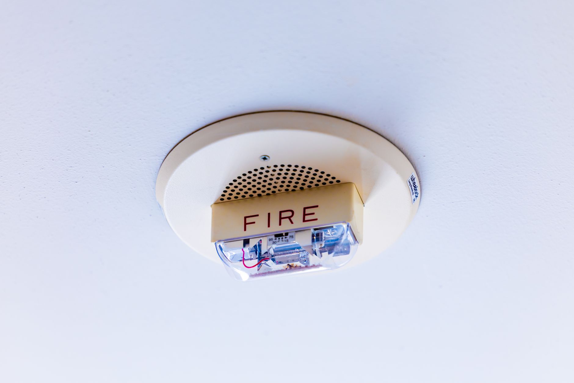 Ceiling-mounted smoke alarm, essential in any room where batteries are charged overnight